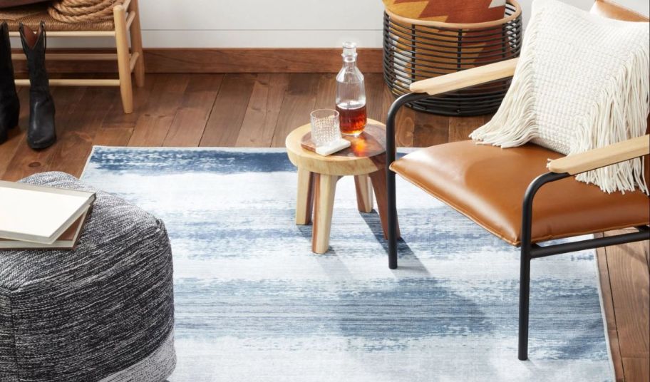 a blue and gray washable area rug on a hardwood floor in a living room