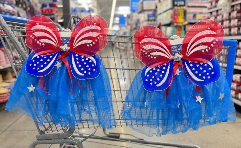 two sets of patriotic tutus and wings hanging on the side of a shopping cart in a walmart store