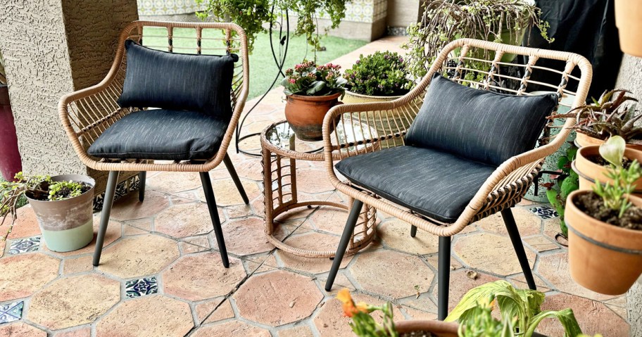 patio chairs with black cushions and matching side table