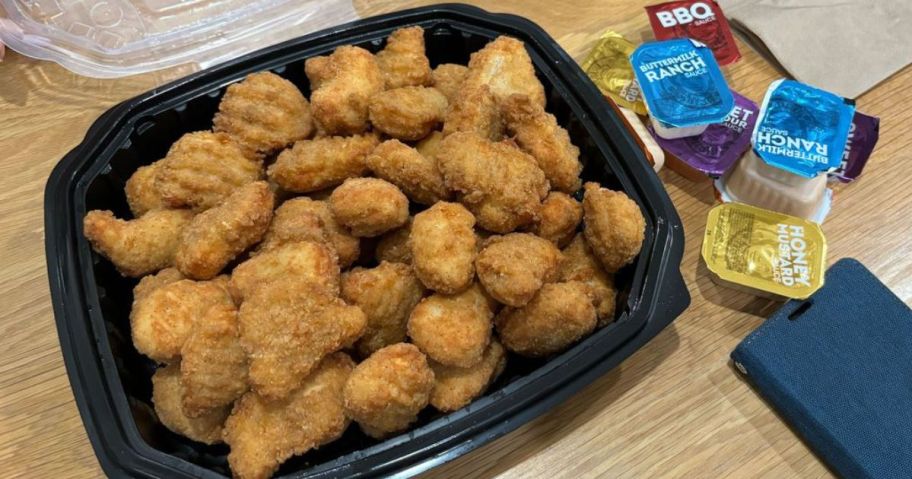 A wendy's chicken nugget party pack with several different sauces 
