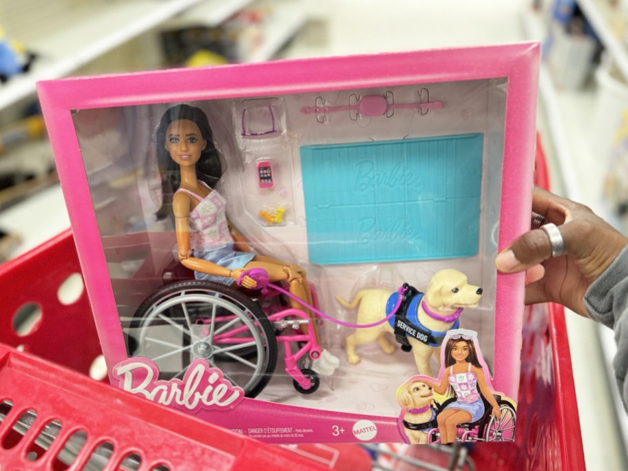 placing a wheelchair barbie set into red target shopping cart