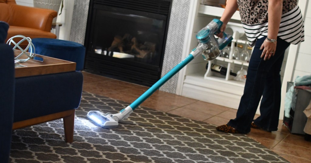 woman vacuuming carpet in living room