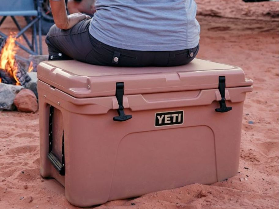 Woman sitting on a pink YETI cooler