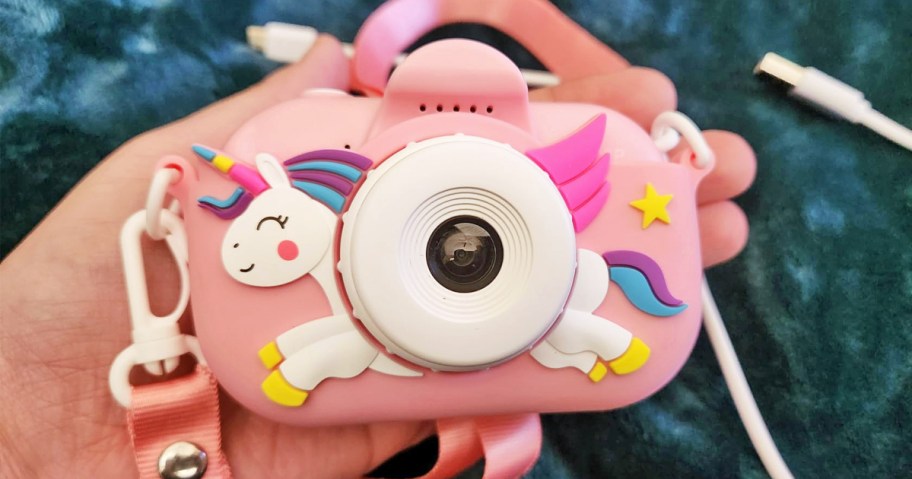 hand holding a pink unicorn kids camera