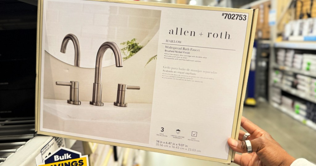 person grabbing box with allen + roth bathroom faucet inside lowe's