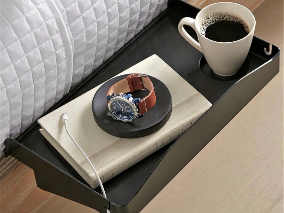 black bedside table with coffee cup and notebook