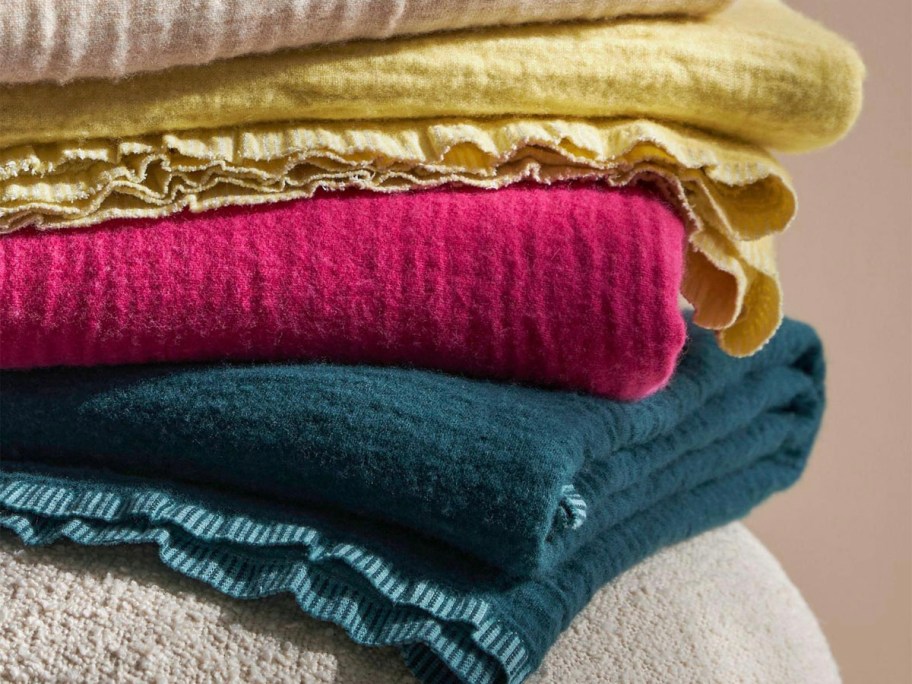 teal, pink and yellow blankets stacked