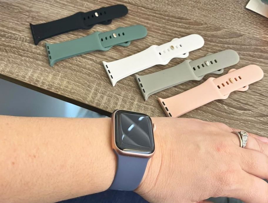 womans wrist with apple watch shown next to watch bands shown with apple watch