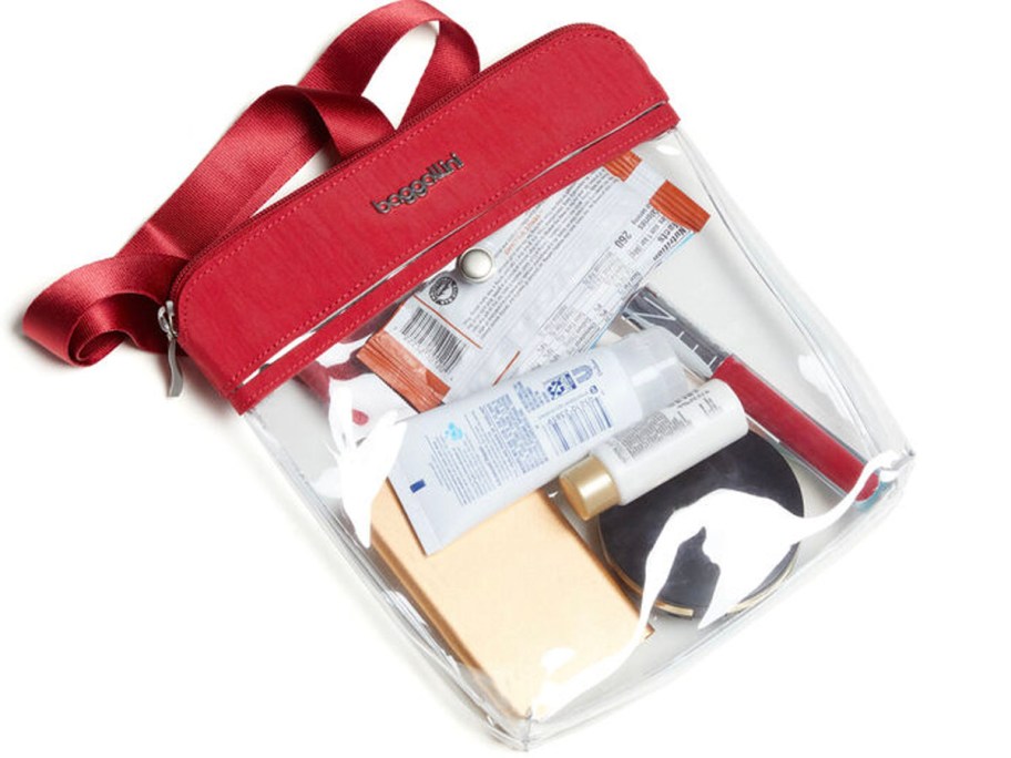 red and clear baggallini crossbody bag with items inside