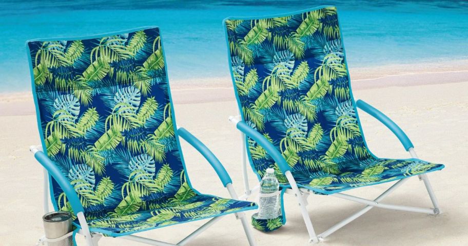 2-Pack Mainstays Folding Low Seat Soft Arm Beach Bag Chair with Carry Bag, Green Palm sitting on sand in front of the ocean