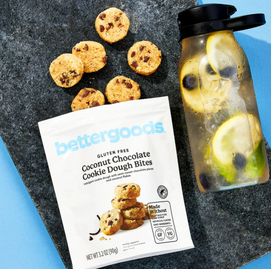 bettergoods Gluten Free Coconut Chocolate Chip Cookie Dough Bites next to a tumbler of water