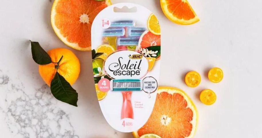 BIC Soleil Escape Razors, Citrus Scented Handles, Women's, 4-Blade, 4 Count pack sitting amongst oranges and lemons