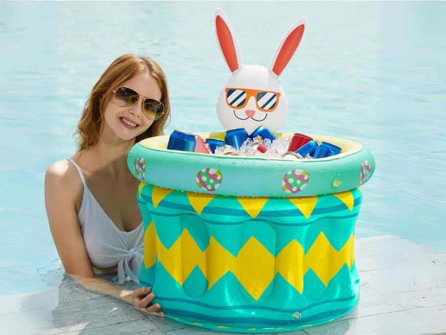 inflatable bunny cooler with ice and drinks inside next to woman at pool