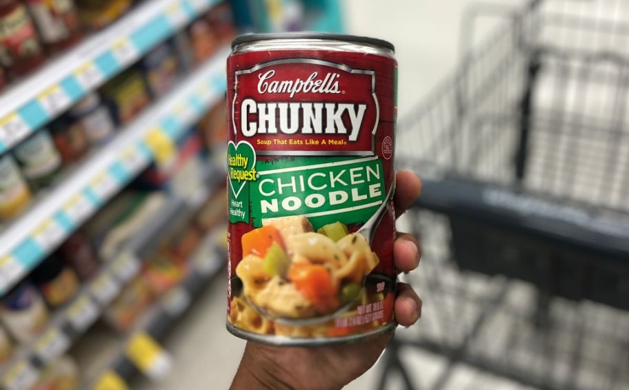 a womans hand holding a can of campbells chunky soup