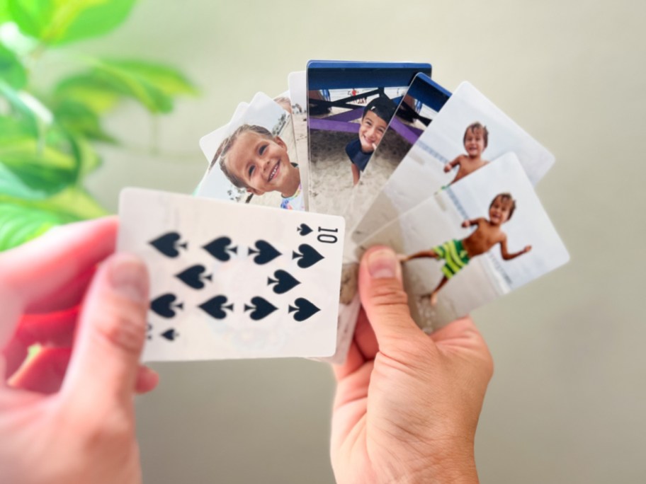 hands holding photo playing cards fanned out