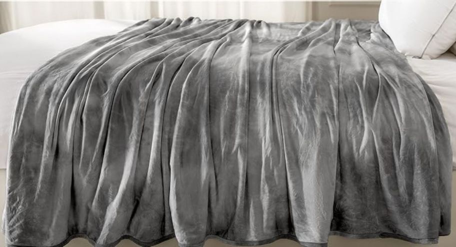 gray tie dye cooling blanket draped across a bed