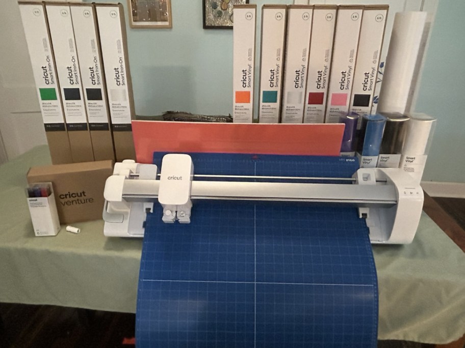 large Cricut Venture machine with rolls and boxes of vinyl decals