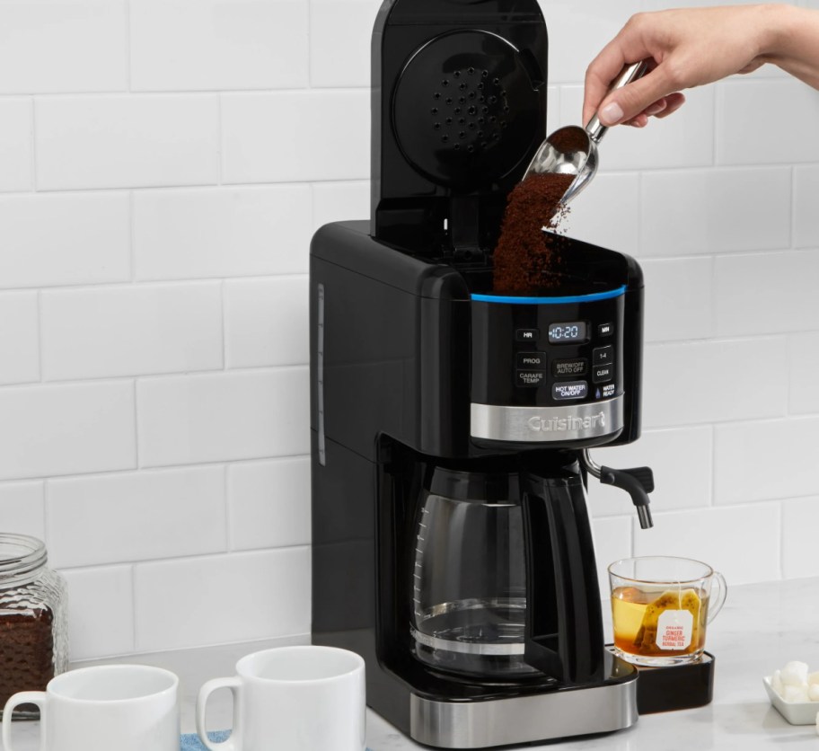 hand scooping coffee into coffee maker