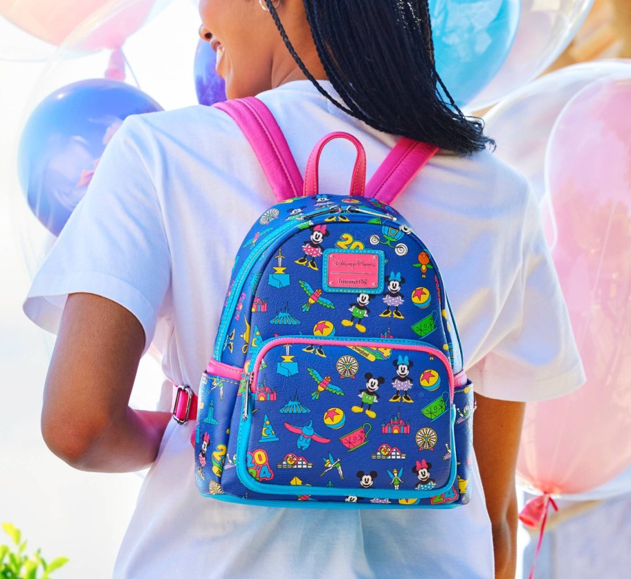 woman wearing pink and blue disney backpack