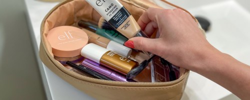 hand reaching into a makeup case for elf cosmetics products