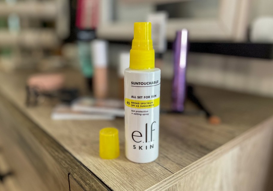 elf Cosmetics Suntouchable SPF spray on a vanity table 