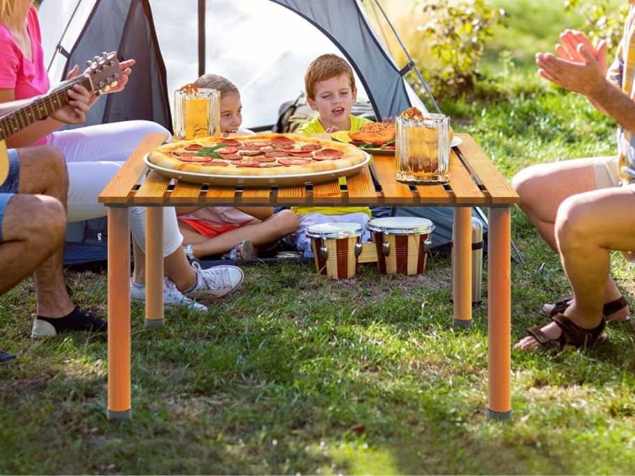 family around wooden table at campground