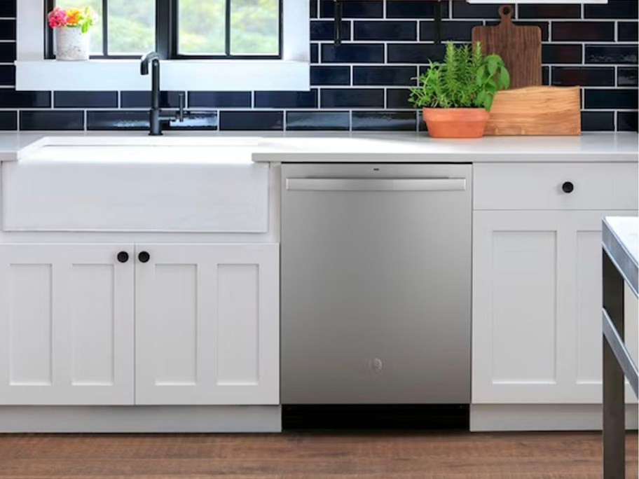 stainless steel dishwasher in between white cabinets