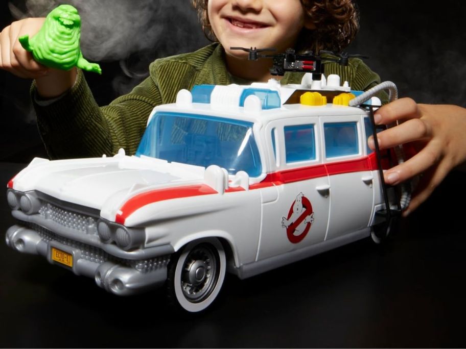 boy playing with slimer and Ghostbusters Track & Trap Ecto-1 Toy Vehicle with Fright Features Ecto-Stretch Tech Slimer Accessory, Compatible with 5-Inch Toys, 4+