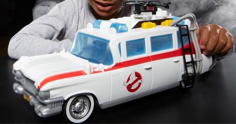 boy playing with Ghostbusters Track & Trap Ecto-1 Toy Vehicle with Fright Features Ecto-Stretch Tech Slimer Accessory, Compatible with 5-Inch Toys, 4+