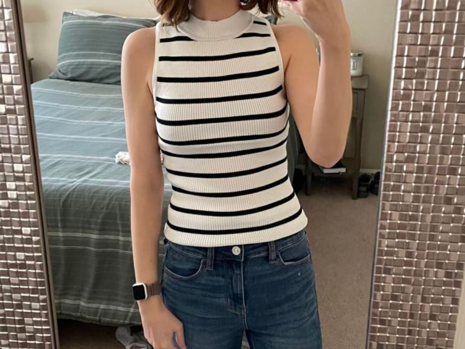 woman wearing a ZESICA Womens Ribbed Tank Tops High Neck Slim Fitted Striped Basic Casual Summer Sleeveless Shirts taking a selfie in front of a mirror