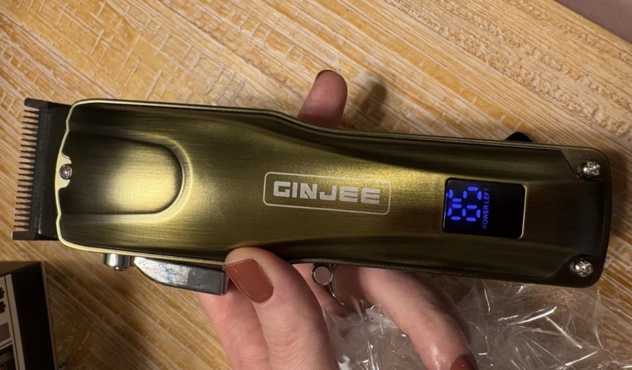 womans hand holding a hair clipper