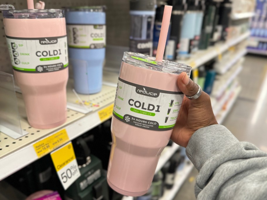hand holding reduce tumbler in pink displayed at the store