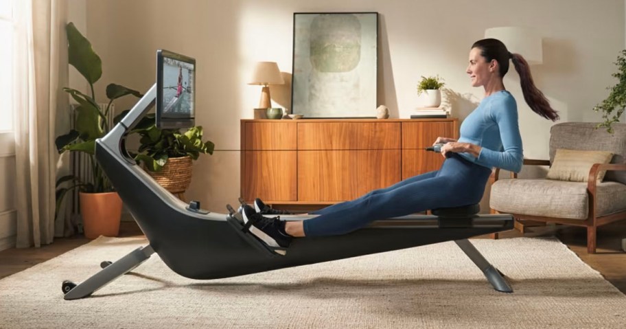 girl using hydrow rowing machine in living room