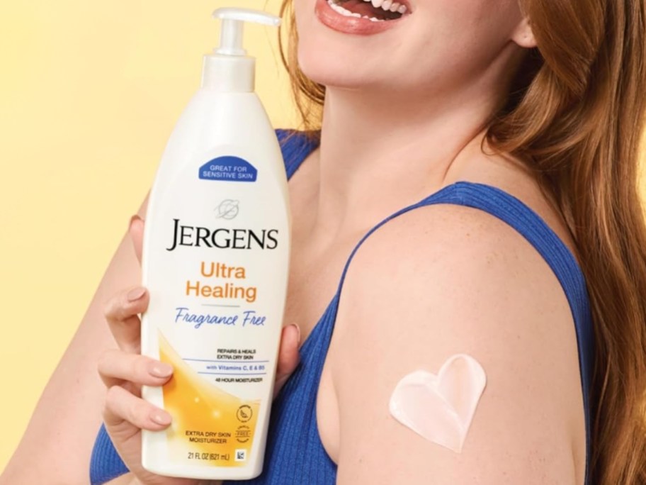 woman holding a bottle of Jergens Ultra Healing lotion