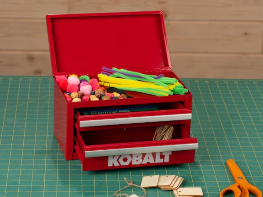 a red mini Kobalt toolbox with craft supplies in it and around it