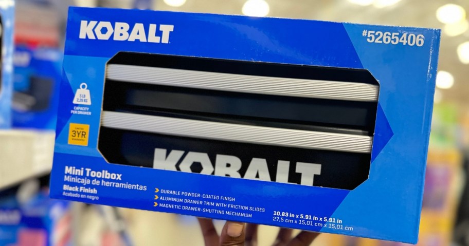 hand holding a blue box with a black Kobalt mini toolbox in it in a Lowes store aisle