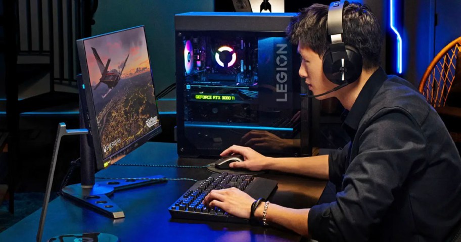 boy playing on gaming computer with keyboard wearing headset