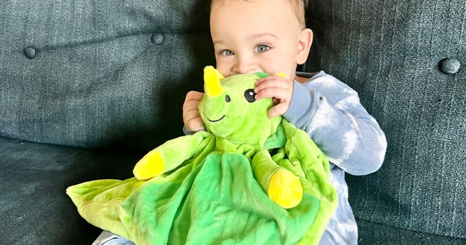 boy holding dragon plush on couch