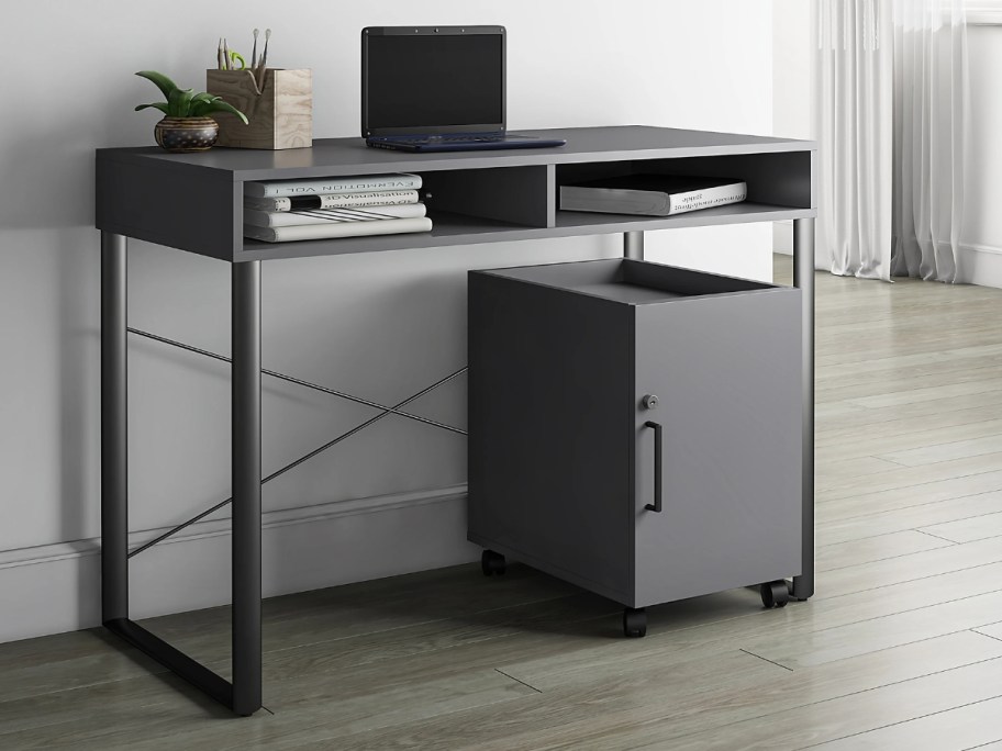 grey and black desk with a mobile storage cart in an office