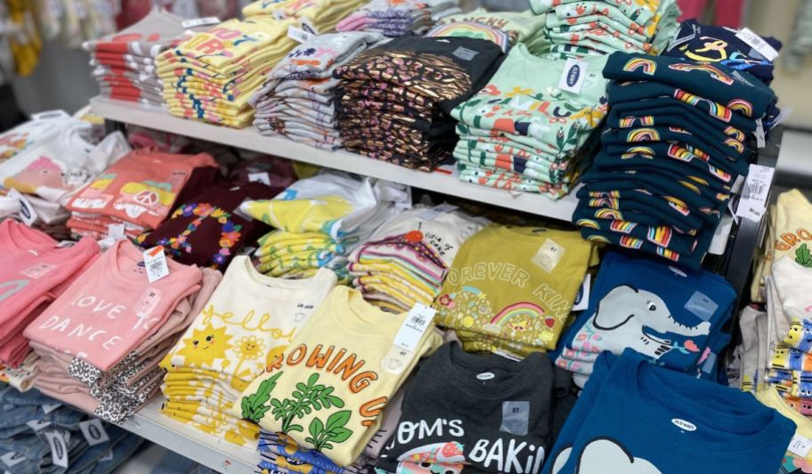 a table of folded kids graphic tees in an old navy store