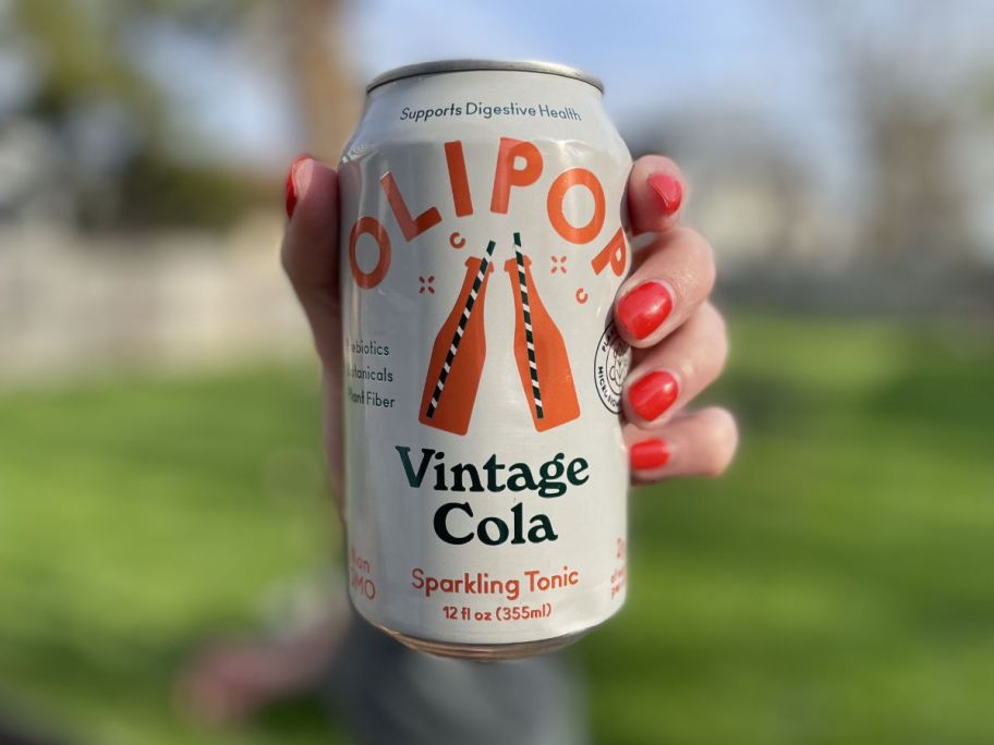 hand holding olipop soda can outside