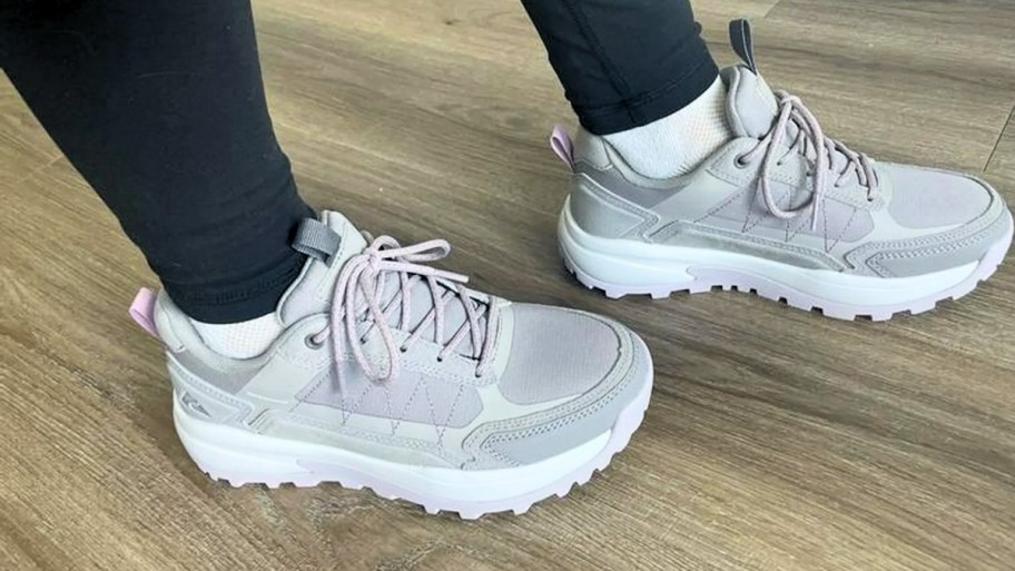 a womans feet in a pair of grey hiking shoes
