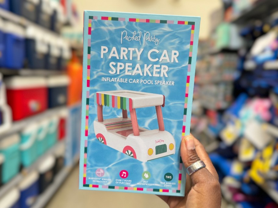 hand holding a car shaped party speaker in the box in car