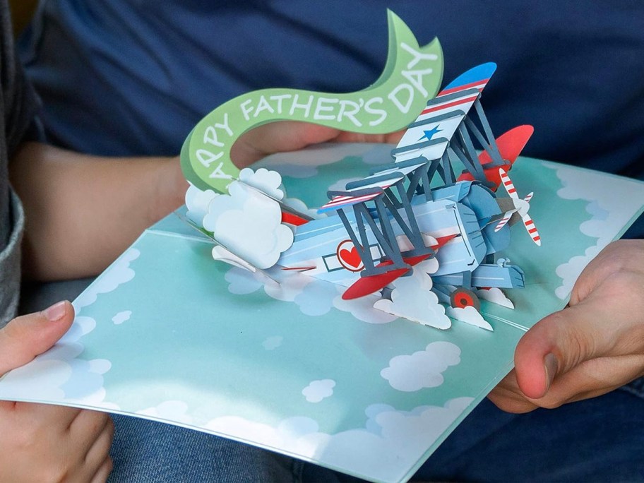 hands holding plane popup card