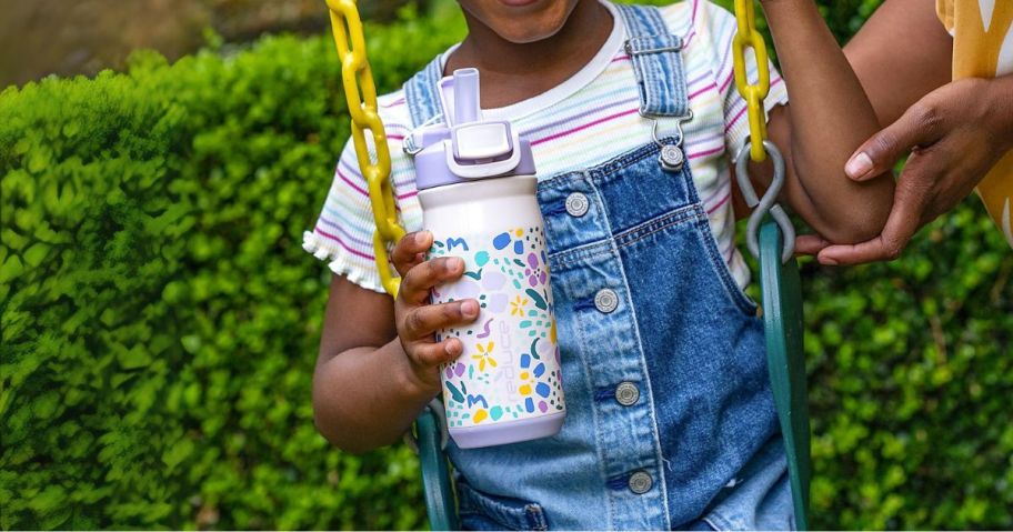 girl holding reduce tumbler on the swing