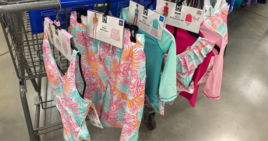 bright tropical floral matching family swimsuits hanging on a Sam's Club shopping cart