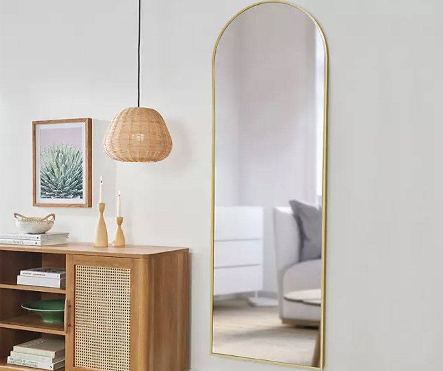 gold framed arch mirror hanging on wall 