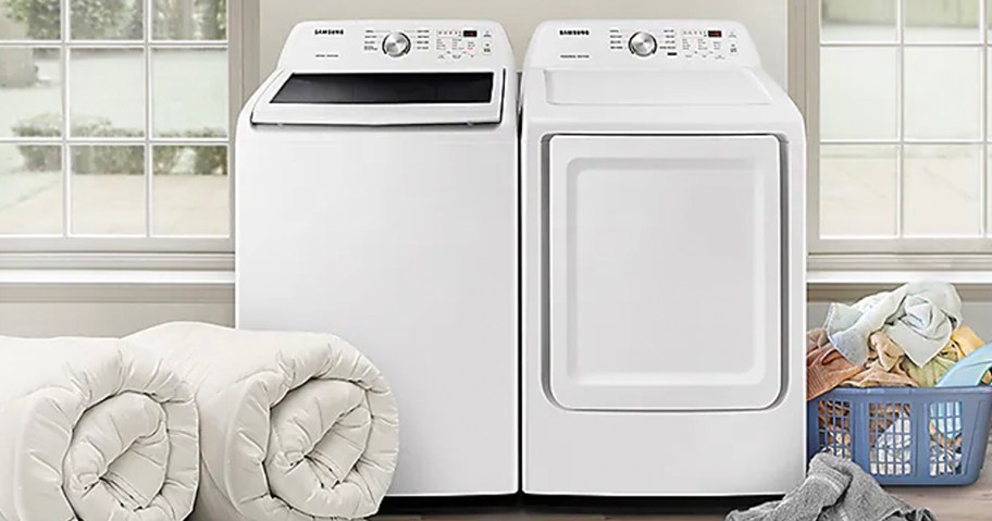 white washer and dryer in launry room with blankets rolled next to it