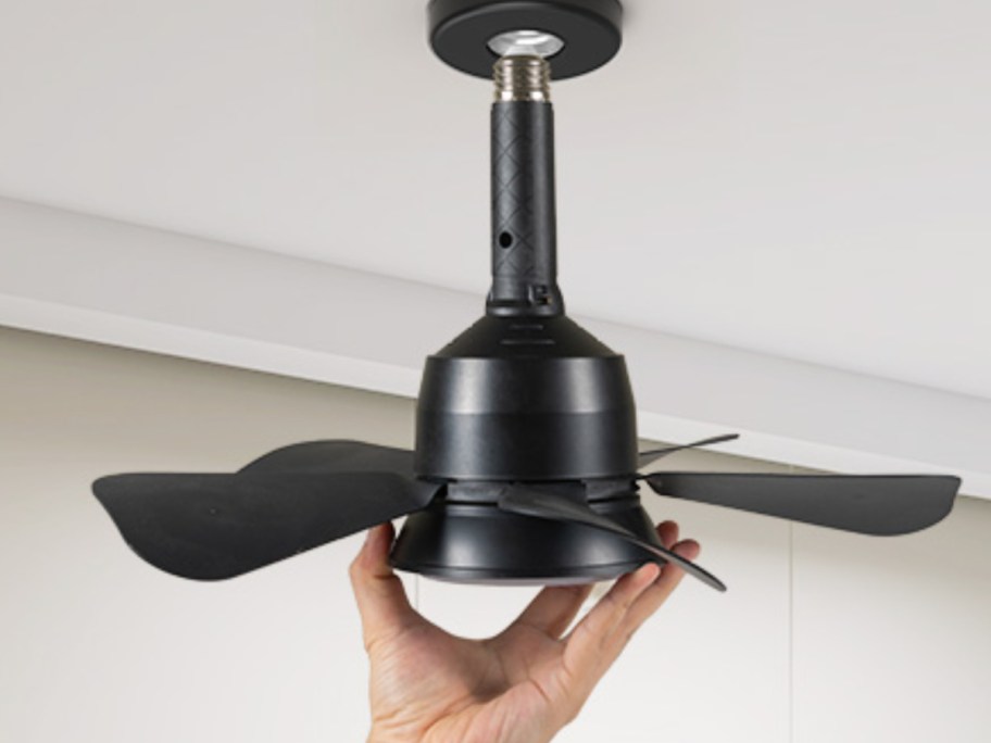 hand screwing fan into socket