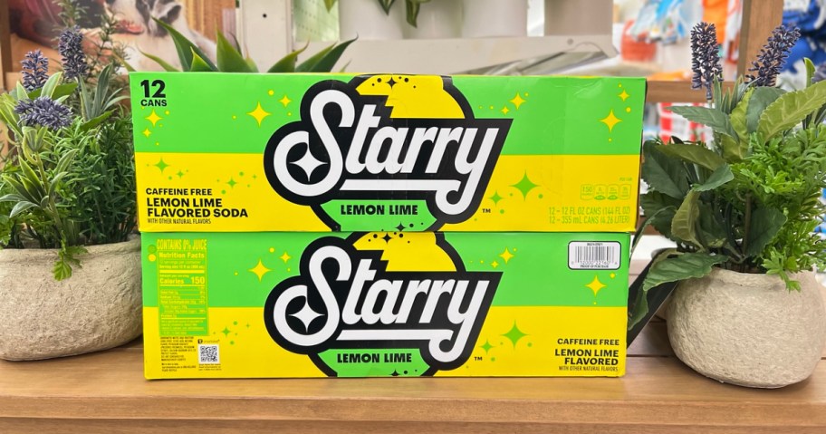 two starry soda 12-packs stacked between 2 faux plants